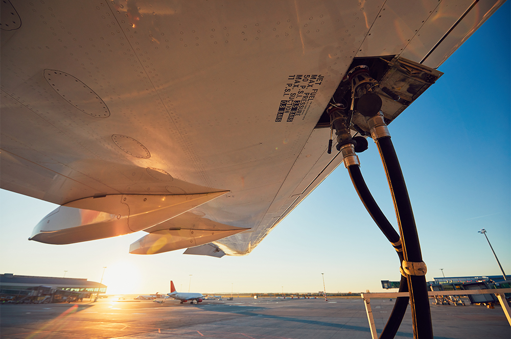 airplane refueling on airport runway with sunset